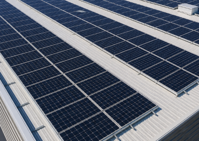 Large-scale rooftop solar panel installation on a commercial building showing aligned photovoltaic system layout